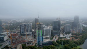 An aerial of The Travis Building in downtown Austin mid-construction on a foggy day.