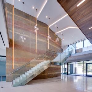 lobby with a sedimentary wall and terrazzo staircase and floor.